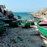 Sulla spiaggia di pietre e ciottoli incastonata tra le due pareti di rocce e su cui sono ormeggiati alcuni �gozzi�, le barche tipiche dei pescatori